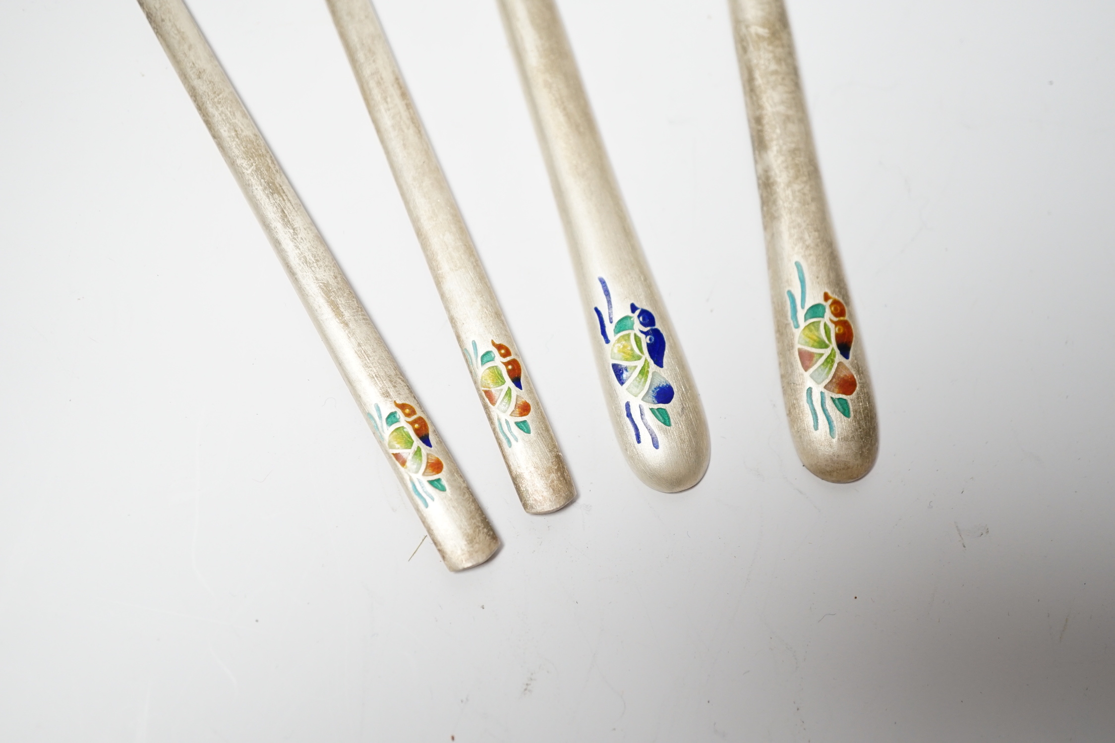 A Korean 990 standard white metal pair of chopsticks, 20cm and two matching spoons with enamelled decoration.